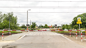 Zamknięte szlabany na przejeździe kolejowo-drogowym.