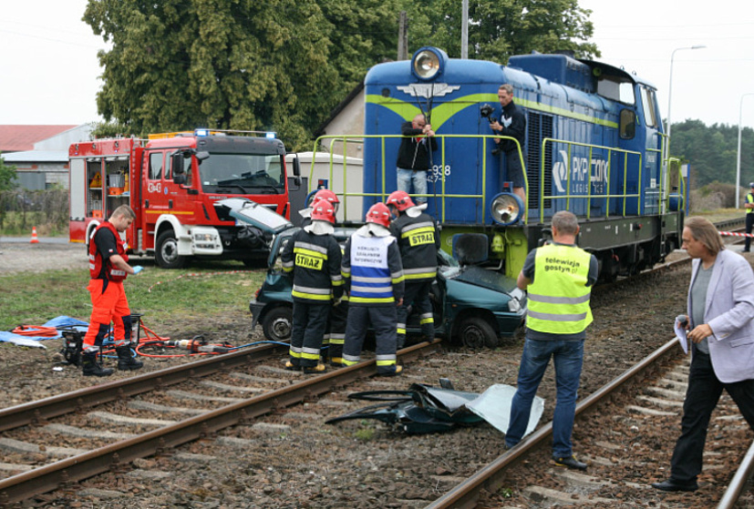 Wrak samochodu, obok lokomotywa, służby ratunkowe podczas pracy. Inscenizacja miejsca wypadku.