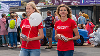 Dwie hostessy w koszulkach kampanijnych roznoszące ulotki