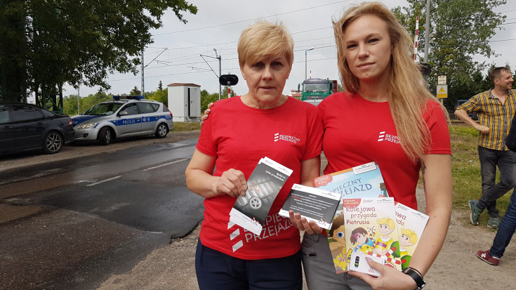 Dwie wolontariuszki, w kampanijnych koszulkach trzymające ulotki.